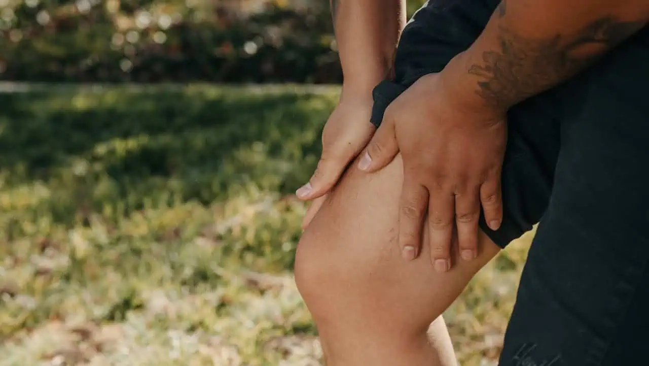 Persona palpando su rodilla